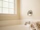 Bright bathroom featuring a white bathtub with chrome fixtures and a textured glass window at 465 Blue Dragonfly Dr, Charleston, SC 29414