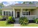 Inviting front porch with white railings, potted plants, and a black front door at 465 Blue Dragonfly Dr, Charleston, SC 29414