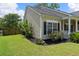 Well-maintained lawn with tasteful landscaping and curb appeal to this home with neutral-colored siding and black shutters at 465 Blue Dragonfly Dr, Charleston, SC 29414