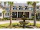 Close up of the exterior with brick stairs leading to a detailed water fountain, with palm trees, and well-manicured landscaping at 4855 Retriever Rd, Wadmalaw Island, SC 29487