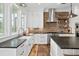 Well-lit kitchen with stainless steel appliances, black countertops, exposed brick, and hardwood floors at 4855 Retriever Rd, Wadmalaw Island, SC 29487