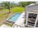 Aerial view of a modern pool, patio, and screened porch, seamlessly blending indoor and outdoor living at 4855 Retriever Rd, Wadmalaw Island, SC 29487