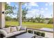 Relaxing screened porch with plush seating and beautiful views of the lush, green landscape at 4855 Retriever Rd, Wadmalaw Island, SC 29487
