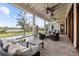 Expansive covered porch with comfortable seating, ceiling fans, and views of the pool and grounds at 4855 Retriever Rd, Wadmalaw Island, SC 29487