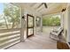 A screened in porch features rocking chairs, and a view of a sprawling lawn at 4855 Retriever Rd, Wadmalaw Island, SC 29487