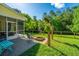 Expansive backyard featuring a screened porch, firepit, manicured lawn, and lush greenery at 493 Nelliefield Trl, Wando, SC 29492