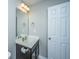 Well-lit bathroom with a dark wood vanity, white sink, and large mirror at 493 Nelliefield Trl, Wando, SC 29492