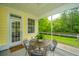 Relaxing screened porch with patio furniture overlooking the fenced backyard and greenery at 493 Nelliefield Trl, Wando, SC 29492