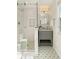 This modern bathroom has a gray vanity, glass shower, and elegant flower-patterned tile floors at 5 Smith St, Charleston, SC 29401