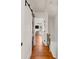 Hallway showing hardwood floors with a barn door concealing laundry appliances and an adjacent room with desk at 5 Smith St, Charleston, SC 29401