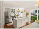 Well-lit kitchen with white marble countertops, stainless appliances, and open access to the dining area at 5 Smith St, Charleston, SC 29401