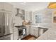 Well-appointed kitchen with stainless steel appliances, white cabinetry, marble countertops and farmhouse sink at 5 Smith St, Charleston, SC 29401
