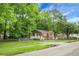 Street view of a charming brick home with light blue shutters and mature trees at 5056 Piedmont Ave, North Charleston, SC 29406