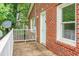 View of a charming brick home, showing a side door, brick facade, and fenced yard at 5056 Piedmont Ave, North Charleston, SC 29406