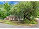 Charming brick home with light blue door and shutters surrounded by mature trees on a corner lot at 5056 Piedmont Ave, North Charleston, SC 29406