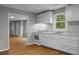 Charming kitchen boasts white cabinets, modern appliances, and seamless access to the living room at 5056 Piedmont Ave, North Charleston, SC 29406