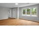 Inviting living room boasts light wood flooring, a front door, and large windows at 5056 Piedmont Ave, North Charleston, SC 29406