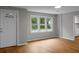Bright living room with light wood flooring, a large window and a white front door at 5056 Piedmont Ave, North Charleston, SC 29406