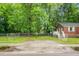 View of the fenced yard next to a charming brick home with mature trees at 5056 Piedmont Ave, North Charleston, SC 29406