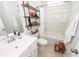 Bright bathroom features a white vanity, toilet, and tub/shower combination with tile flooring and wood shelving at 524 Richfield Way, Summerville, SC 29486