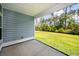 Covered patio with concrete flooring and views of the manicured lawn and verdant trees at 524 Richfield Way, Summerville, SC 29486
