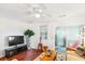 Cozy living room with a TV, ceiling fan, hardwood floors, access to outdoor deck, and natural light at 525 Tayrn Dr, Wando, SC 29492
