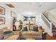 Comfortable living room with plush sofas, decor, staircase and view into the dining area and kitchen at 525 Tayrn Dr, Wando, SC 29492