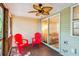 Relaxing screened-in patio with ceiling fan, wood flooring, and red Adirondack chairs at 525 Tayrn Dr, Wando, SC 29492