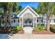 Exterior view of the community pool house flanked by palm trees and landscaping at 525 Tayrn Dr, Wando, SC 29492