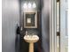 Elegant half bathroom with pedestal sink, ornate mirror, and stylish lighting at 525 Tayrn Dr, Wando, SC 29492