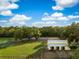 Aerial view of equestrian property with barns, grazing land, riding area, and serene, tree-lined surroundings at 5348 Mccullough Dam Rd, Wadmalaw Island, SC 29487