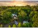 Secluded home nestled among lush trees with a stone pathway and fire pit, offering privacy and outdoor enjoyment at 5348 Mccullough Dam Rd, Wadmalaw Island, SC 29487