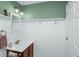Half bathroom with wainscotting features vanity with storage space and a decorative mirror at 5348 Mccullough Dam Rd, Wadmalaw Island, SC 29487