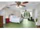 Spacious bedroom with unique green floors, ceiling fan, and a cozy seating area near the window at 5348 Mccullough Dam Rd, Wadmalaw Island, SC 29487