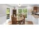 Bright dining area featuring wood table, chairs, and large windows overlooking the backyard at 5348 Mccullough Dam Rd, Wadmalaw Island, SC 29487