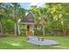 Beautiful home with a charming front porch, American flag, palm trees, and a cozy fire pit area at 5348 Mccullough Dam Rd, Wadmalaw Island, SC 29487