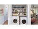 Convenient laundry closet boasts a washer, dryer, and plenty of shelving for organized storage solutions at 5348 Mccullough Dam Rd, Wadmalaw Island, SC 29487