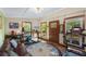 Living room featuring exercise equipment, nautical rug, and a large window looking out onto the surrounding landscape at 5348 Mccullough Dam Rd, Wadmalaw Island, SC 29487