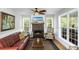 Bright living room featuring a fireplace, large windows, comfortable seating, and a ceiling fan at 5348 Mccullough Dam Rd, Wadmalaw Island, SC 29487