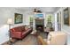 Well-lit living room with a brick fireplace, comfortable sofa and chairs, and multiple windows at 5348 Mccullough Dam Rd, Wadmalaw Island, SC 29487