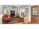Cozy living room with a brick fireplace, multiple windows, comfortable seating, and natural light at 5348 Mccullough Dam Rd, Wadmalaw Island, SC 29487