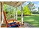Picturesque porch with a cozy rocking chair overlooking lush landscaping, perfect for relaxing outdoors at 5348 Mccullough Dam Rd, Wadmalaw Island, SC 29487