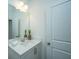 Neutral-toned bathroom with a white vanity and an elegant lighting and mirror arrangement at 602 Twin Rivers Dr, Wando, SC 29492
