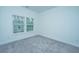 Bright bedroom featuring plush gray carpeting and natural light from two windows at 602 Twin Rivers Dr, Wando, SC 29492