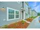 Attractive new townhomes feature white trim, landscaped grounds, and convenient parking on a sunny day at 602 Twin Rivers Dr, Wando, SC 29492