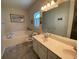 Bathroom featuring double sink vanity, and a soaking tub under a bright window at 7517 Whispering Oak Dr, Hanahan, SC 29410