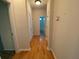 Hallway with hardwood floors, white trim, and doorways leading to other rooms at 7517 Whispering Oak Dr, Hanahan, SC 29410