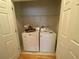 Efficient laundry area with white washer and dryer, plus overhead shelving for storage at 7517 Whispering Oak Dr, Hanahan, SC 29410