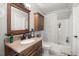This bathroom offers a wooden vanity, a framed mirror, and a shower and tub combination at 7921 Cricket Ct # 305 E, North Charleston, SC 29418