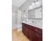 Bathroom features a cherry vanity, framed mirror, tub and shower with wooden floors at 9524 Markley Blvd, Summerville, SC 29485